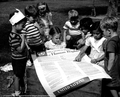 Children at the United Nations International Nursery School look at a poster of the Universal Declaration of Human Rights