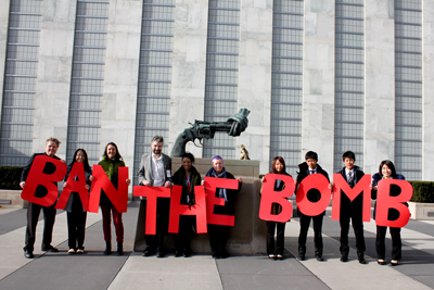 ICAN representatives hold sign saying "Ban the Bomb" in United Nations Plaza, NY during Nuclear Ban Treaty Negotiations